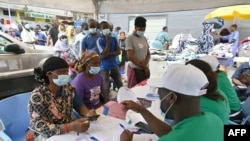 People queue to receive a Pfizer COVID-19 vaccine dose at the Ajame main market on Aug. 27, 2021 during a massive COVID-19 vaccination campaign in Abidjan, Côte d'Ivoire.