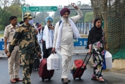 Sikh pilgrims return from Pakistan after celebrating the Baisakhi festival at India-Pakistan Wagah border, about 35 kms from Amritsar, April 22, 2021.