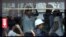 A commuter wears a construction helmet while sitting inside a crowded bus in Zhanjiang, China's Guangdong province on Thursday, June 28, 2012.