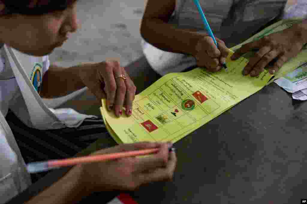 Para sukarelawan menyiapkan kertas suara untuk para pemilih di TPS di Dala, sebuah desa di luar Yangon, 8 November 2015.