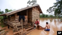 Kongvilay Inthavong and his wife Thongla clean up their house as the floodwaters start to recede in Sanamxay district, Attapeu province, Laos on Thursday, July 26, 2018. Authorities and the builder are investigating why a dam in southeastern Laos collapsed earlier this week, killing at least two dozen people and leaving over a hundred missing. (AP Photo/Hau Dinh)