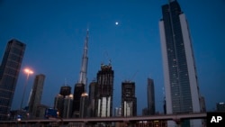 A lone taxi cab rushes down the largely empty 12-lane Sheikh Zayed Road in front of the Burj Khalifa, the world's tallest building, in Dubai, United Arab Emirates, is now under a 24-hour lockdown over the new coronavirus pandemic