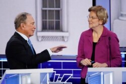 Democratic presidential candidates, former New York City Mayor Mike Bloomberg, left, and Sen. Elizabeth Warren, D-Mass., talk during a break at a Democratic presidential primary debate, Feb. 19, 2020, in Las Vegas.