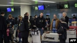 Foreign diplomats, embassy staff, and their families check-in for a flight to Vladivostok at Pyongyang International Airport on March 9, 2020. - Several embassies in North Korea closed as many diplomats were flown out following weeks of tight…