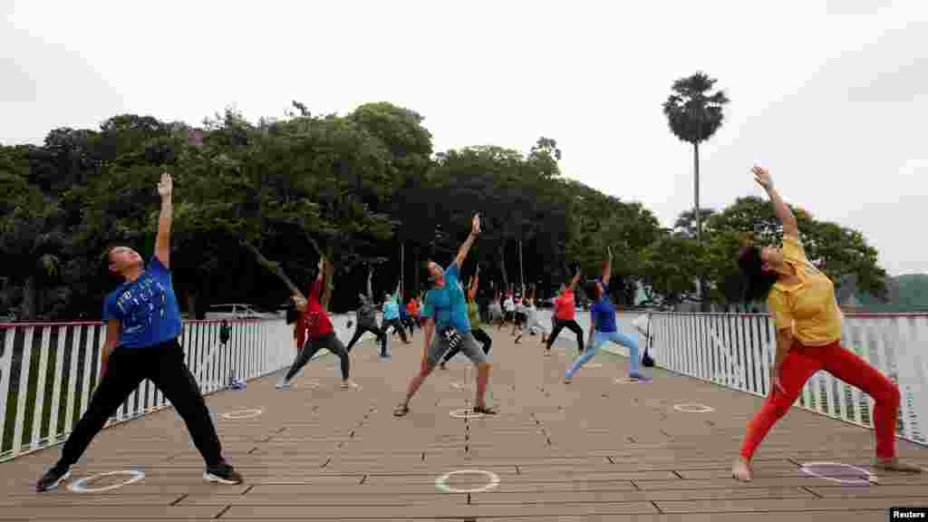 En Yangon, Myanmar, un grupo de personas hace ejercicio guardando la distancia que exigen las autoridades sanitarias para cuando se está en espacios públicos. Los círculos dibujados en el piso marcan el lugar donde deben estar quienes participan en esta clase colectiva.