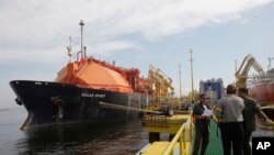 Los trabajadores se paran en el nuevo Petroleo Brasileiro SA, o la terminal de gas natural licuado de Petrobras en la bahía de Guanabara en Río de Janeiro, el miércoles 18 de marzo de 2009. (Foto AP / Archivo)