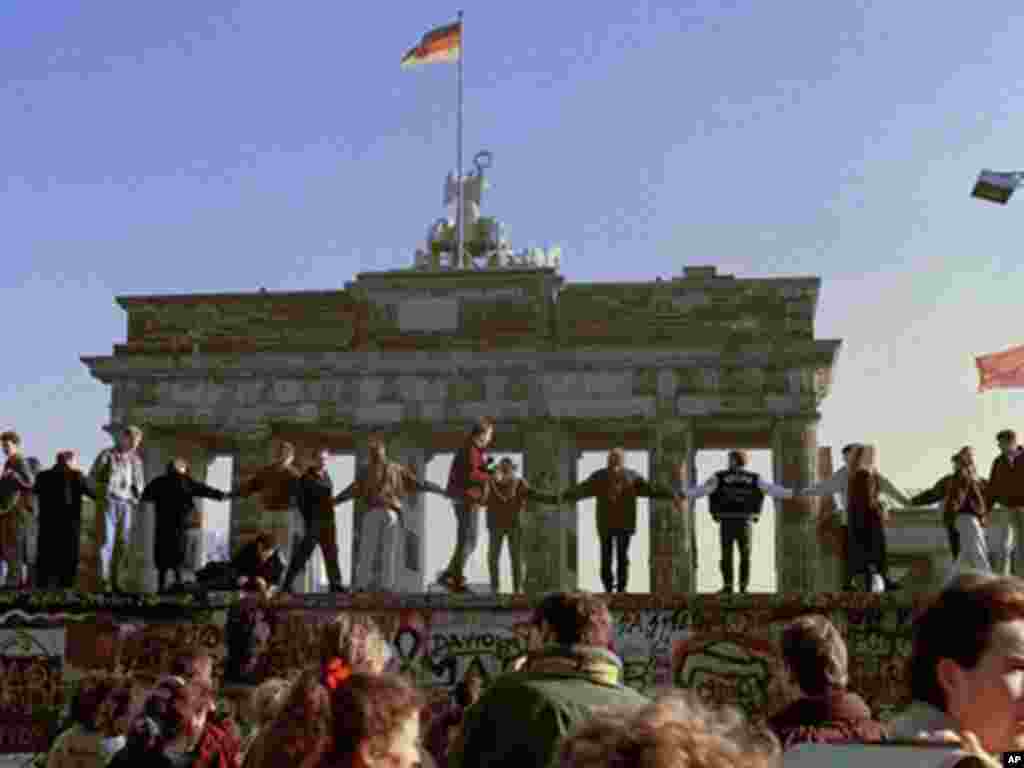 November 10, 1989: Berliners dancing on top of the Berlin wall, which fell in part due to Mr. Gorbachev's non-interventionist policy. (AP)