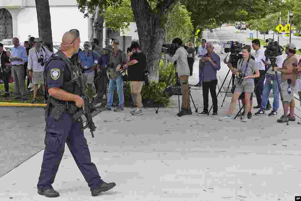 A Department of Homeland Security officer, left, prepares to block traffic for a prisoner transport van at the Paul G. Rogers Federal Building and U.S. Courthouse, where a man suspected in an assassination attempt targeting former President Donald Trump, was charged with federal gun crimes, in West Palm Beach, Florida.