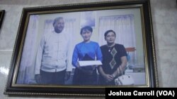 A picture hanging in Ko Ni's family home shows him and his wife (right) posing with Aung San Suu Kyi.