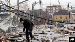 Un hombre busca entre los escombros por pertenencias que pueda rescatar de su casa luego que violentos tornados devastaran la zona central de Tennessee el lunes por la tarde. Más de 20 personas han muerto. 