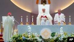 Pope Francis, seated left, presides over Mass at the SportsHub National Stadium in Singapore, Sept. 12, 2024.