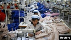 FILE - North Korean employees, shown in December 2013, sew in a South Korean-owned company at the Kaesong industrial park just north of the demilitarized zone. 