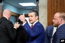 FILE - Pete Hegseth, President Donald Trump's nominee for defense secretary, gives a thumbs up while leaving after his Senate Armed Services Committee confirmation hearing, at the Capitol in Washington, Jan. 14, 2025.