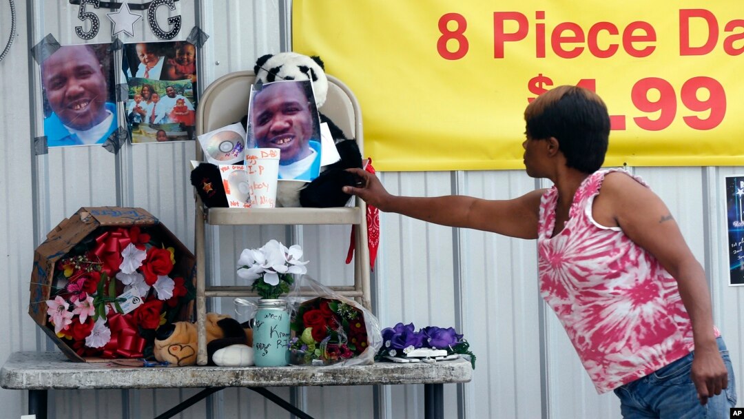 A woman touches a makeshift memorial for Alton Sterling, outside a convenience store in Baton Rouge, Louisiana, July 6, 2016. Sterling was shot and killed by police outside the store.