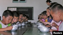 FILE - North Korean children eat lunch at a government-run kindergarten in Taedong county in south Pyongan province, July 18, 2005.