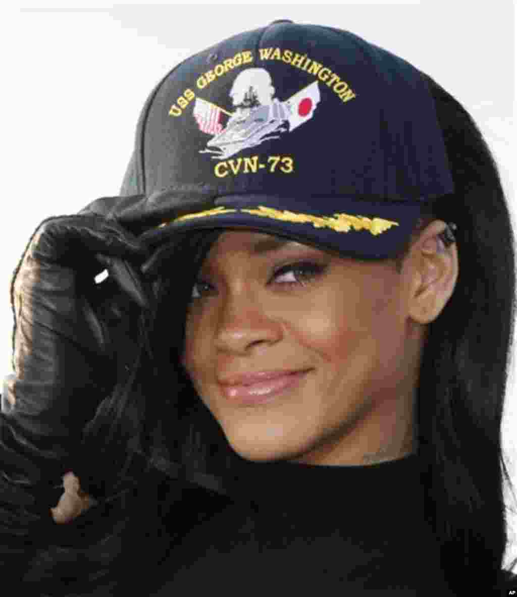 Rihanna smiles as she wears a USS George Washington cap during a photocall of her debut movie "Battleship" promotion event aboard the aircraft carrier at the U.S. 7th Fleet's headquarters in Yokosuka, near Tokyo, Monday, April 2, 2012. (AP Photo/Koji Sasa