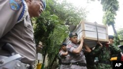 Indonesian police officers and soldiers carry one of the coffins prepared for the victims of a military helicopter which crashed in Poso, Central Sulawesi, at hospital in Jakarta, Indonesia, March 21, 2016. 