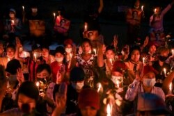 Personas participan en una vigilia con velas para protestar contra el golpe militar en Rangún, Myanmar, el 21 de febrero de 2021.