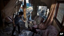 A Palestinian boy cleans his family house in Gaza City, May. 6, 2019, after an Israeli airstrike.