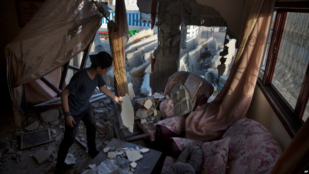 Seorang anak Palestina memeriksa puing-puing rumahnya pasca serangan udara Israel atas kota Gaza, Jalur Gaza bulan lalu (foto: dok). 