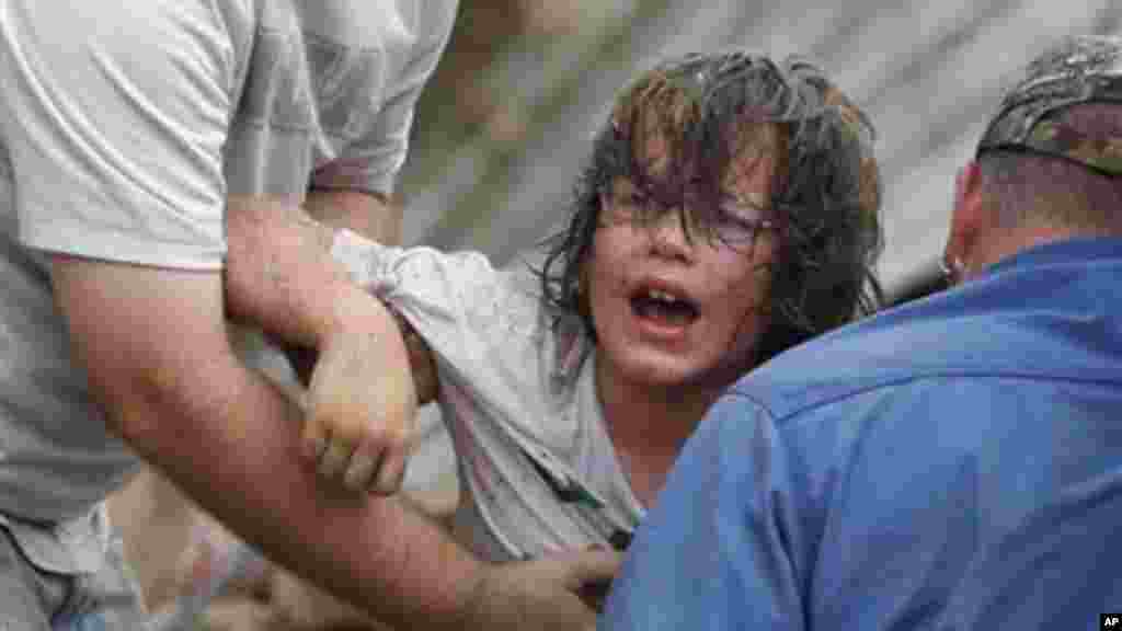 A child calls to his father after being pulled from the rubble of the Tower Plaza Elementary School following a tornado in Moore, Okla., Monday, May 20, 2013.