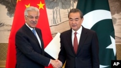 Menteri Luar Negeri Pakistan Khawaja Muhammad Asif (kiri) dan Menteri Luar Negeri China Wang Yi berjabat tangan seusai konferensi pers bersama di Wisma Diaoyutai, Beijing, 8 September 2017. (Foto: dok).