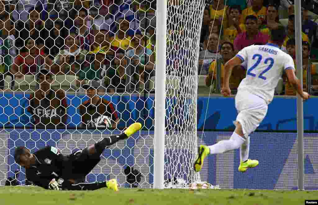 Greece's Andreas Samaris scores past Ivory Coast's Boubacar Barry during their match at the Castelao arena in Fortaleza, June 24, 2014.