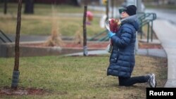 Une femme priant devant la Résidence Herron, un établissement de soins de longue durée pour personnes âgées, à la suite d’un certain nombre de décès du coronavirus, dans la banlieue de Dorval à Montréal, le 13 avril 2020. (REUTERS/Christinne Muschi)