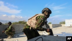 FILE - A Kenyan police officer, part of a UN-backed multinational force, runs to take cover from an exchange of gunfire between gangs and police at the Kenyan base in the Delmas neighborhood of Port-au-Prince, Haiti, Thursday, Dec. 5, 2024. 