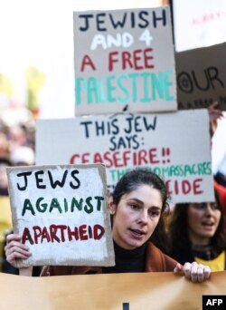 FILE - A protester holds placards while taking part in the 'National March For Palestine' in central London on November 11, 2023, calling for a ceasefire in the conflict between Israel and Hamas.