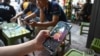 FILE - A man looks at the social media platform TikTok on his smartphone in Hanoi on October 6, 2023.