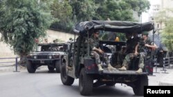 Lebanese Army soldiers sit in their military vehicles as they are deployed to secure the area near the French embassy in Beirut, September 21, 2012.