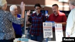 Workers take an oath prior to opening a polling station during voting in the 2016 presidential election in Las Vegas, Nevada, Nov. 8, 2016.