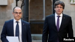 Presiden Catalonia Carles Puigdemont, kanan, berjalan dengan Jordi Turull di Barcelona, Spanyol, 17 Oktober 2017. 