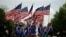 Des gens portent des drapeaux américains pendant qu'ils participent à un défilé lors des célébrations de la fête de l'indépendance du 4 juillet à Washington, D.C., États-Unis, le 4 juillet 2019. REUTERS / Carlos Barria