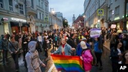 FILE – LGBTQ+ activists hold a rainbow flag at a rally in Pushkin Square, in Moscow, Russia, on July 15, 2020. The crackdown on LGBTQ+ rights has gone on for more than a decade under President Vladimir Putin.