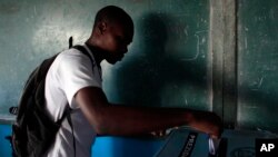 A man casts his ballot at a polling station during national elections in the Petion-Ville suburb of Port-au-Prince, Haiti, Oct. 25, 2015. 