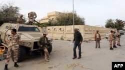 Libyan soldiers, some on an armored personnel carrier (APC), deploy in a Tripoli's neighborhood after militias were ordered to leave the capital following deadly weekend clashes, Nov. 18, 2013. 