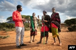 FILE - Lisoka Lesasuyan, 21, (R) listen on with his brother Joshua (2nd R) and father, Lawan (2nd L) to their lawyer, Kelvin Kubai (L) at Kipsing village, Isiolo county on October 18, 2023.