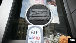 Tributes are placed beneath a covered seal of the U.S. Agency for International Development (USAID) at its headquarters in Washington, on Feb. 7, 2025.