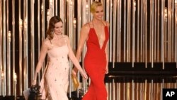 Emily Blunt (kiri) dan Charlize Theron saat membacakan pemenang Oscars 2016 di Los Angeles, 28 Februari lalu. Kedua aktris ini tampil sebagai pemeran utama dalam "The Huntsman: Winter's War." 