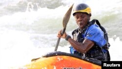 David Egesa, 40, a member of Uganda's kayaking team, paddles against waves during a team practice session in the River Nile in Jinja, east of Uganda's capital, Kampala, Aug. 19, 2015.