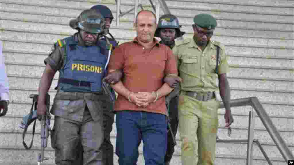 Talal Ahmad Roda, a Nigerian-Lebanese man accused of belonging to Hezbollah, centre, is led out by prison security officers after he was sentenced to life imprisonment at the Federal High Court in Abuja, Nov. 29, 2013.