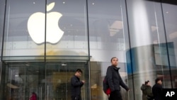 People walk past an Apple store at an outdoor shopping street in Beijing, Feb. 26, 2019. 