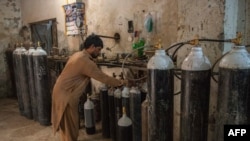 A worker fills oxygen tanks for use in hospitals in Peshawar, Pakistan, Dec. 7, 2020.