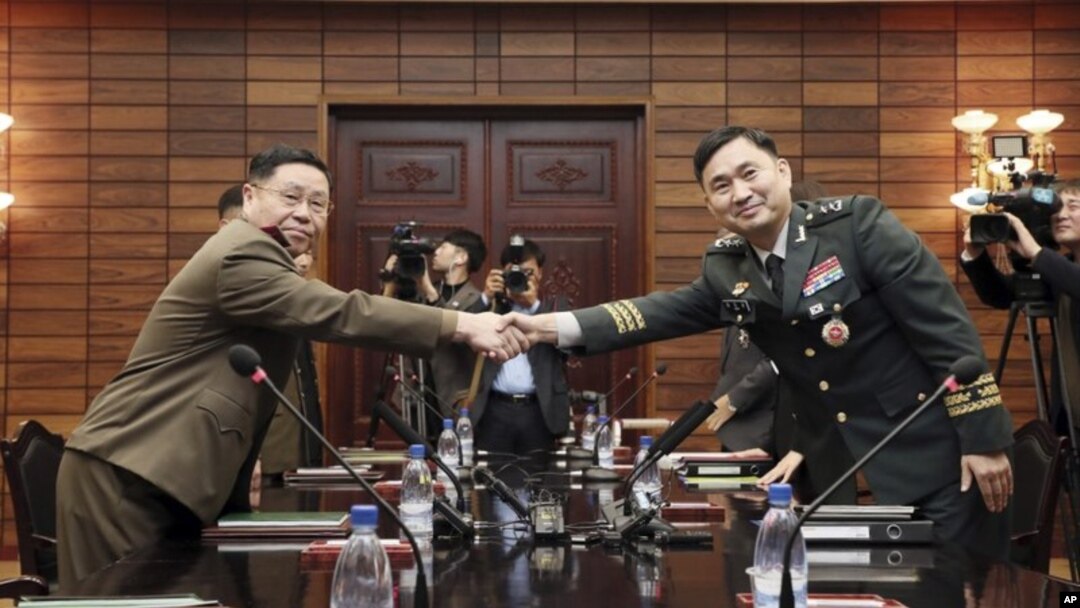 Jenderal Korea Selatan Kim Do-gyun (kanan) berjabat tangan dengan Letnan Jenderal An Ik San dari Korea Utara, di kota perbatasan Panmunjom, Korea Utara, 26 Oktober 2018. (Korea Pool / Yonhap melalui AP)