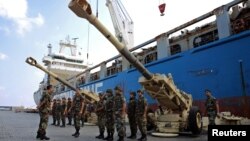Lebanese troops stand near artillery pieces that were unloaded from a ship at Beirut port in Lebanon, Aug. 9, 2016.