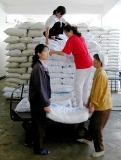 지난 2003년 6월 북한 평양의 한 식료품 공장 노동자들이 세계식량기구(WFP)가 지원한 식량을 옮기고 있다.