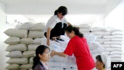 지난 2003년 6월 북한 평양의 한 식료품 공장 노동자들이 세계식량기구(WFP)가 지원한 식량을 옮기고 있다. (자료사진)