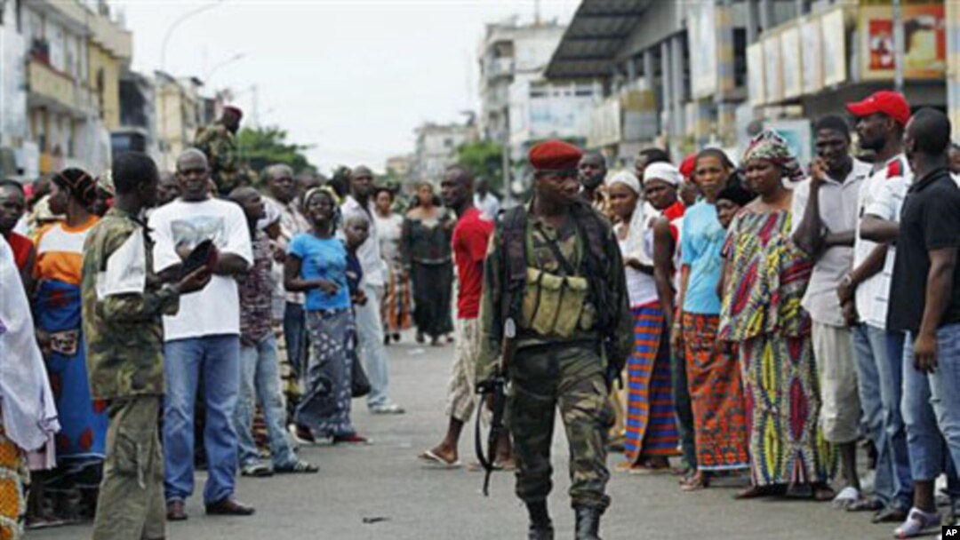 Residents of the Treichville neighborhood gather outside the damaged former base of Laurent Gbagbo's Republican Guards, as soldiers loyal to Alassane Ouattara occupy it, in Abidjan, Ivory Coast, April 15, 2011